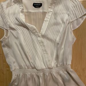 BEBE a white short sleeved peplum top